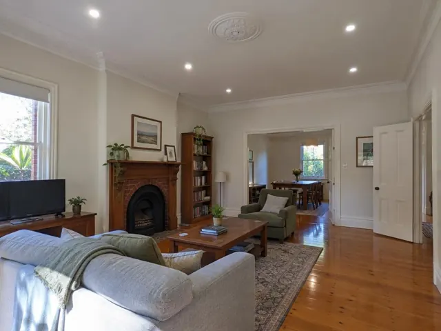 Living room with recessed ceiling downlights, fireplace and timber floors in Marsfield